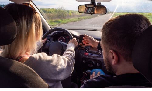 Professional driving instructor guiding a student on how to be confident to drive a car.