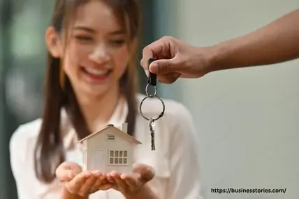 Young first-time homebuyer receiving house keys while holding a model home, representing Millennial and Gen Z homeownership trends in today's housing market.