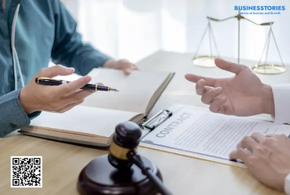 Lawyer explaining why business law is important while reviewing legal documents with a startup owner.